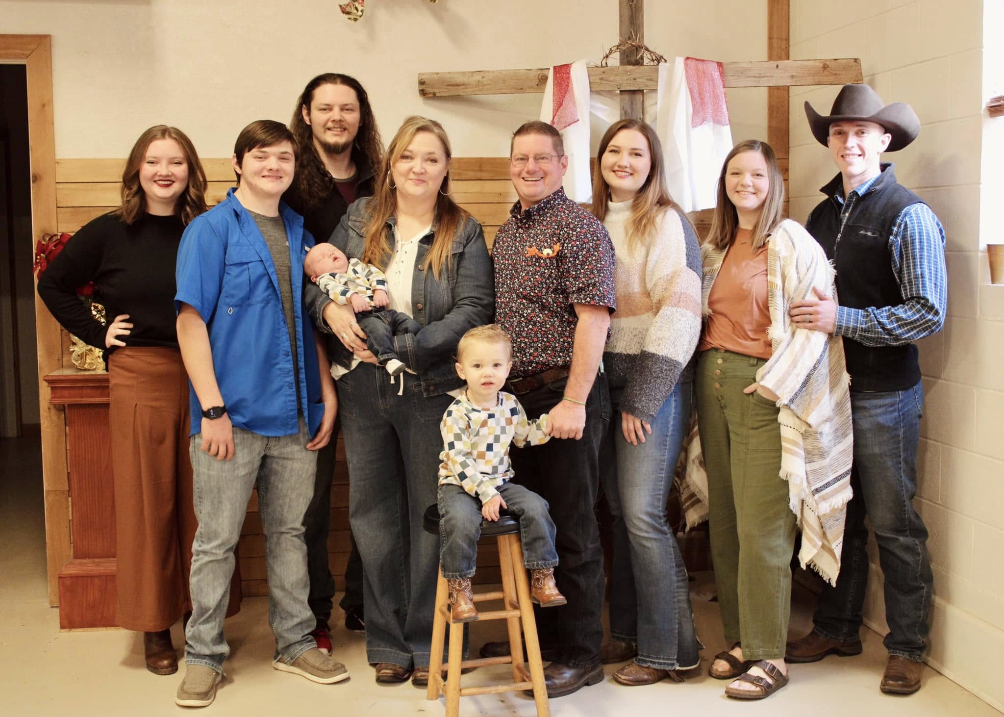 A family group gathered indoors with children.